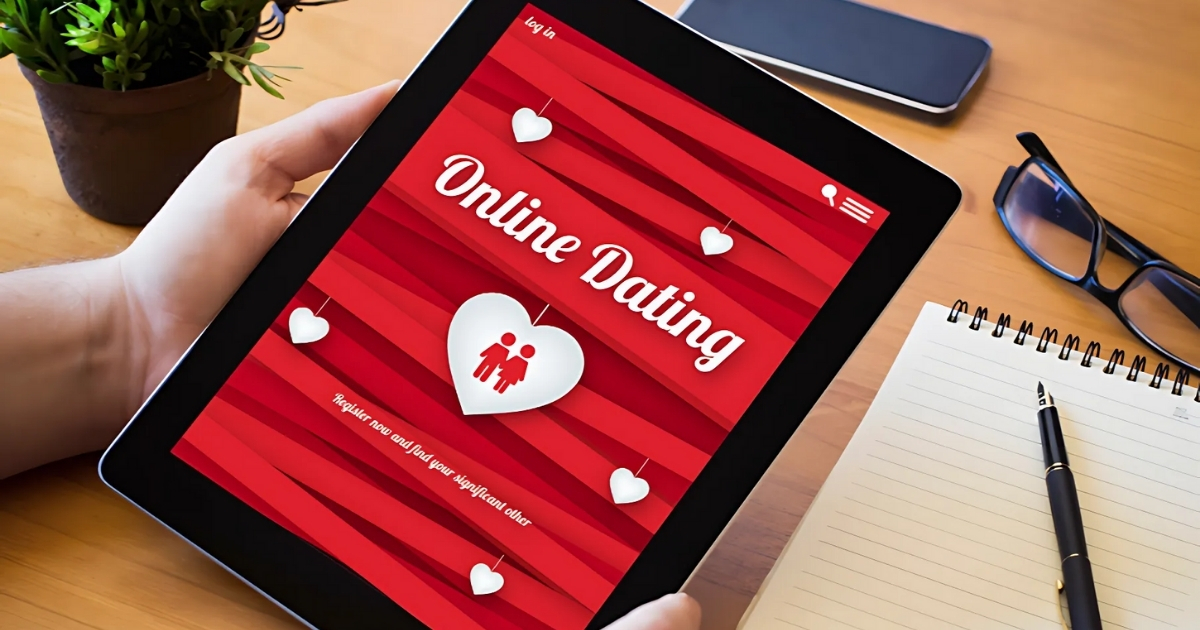 Online dating app on tablet with hearts and red background.