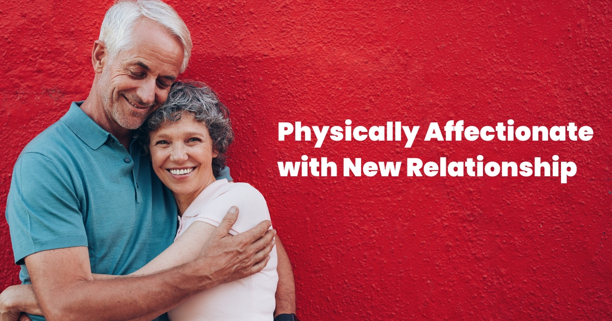 Happy senior couple embracing affectionately against a red wall, symbolizing physical affection in a new romantic relationship