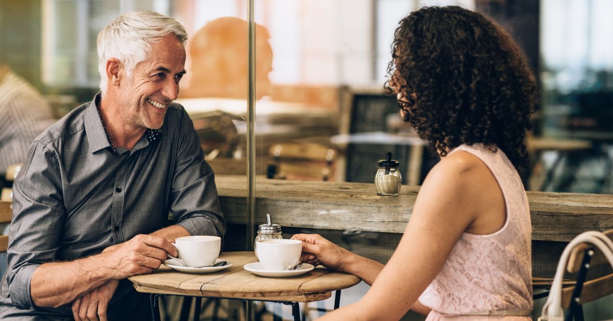 Smiling mature couple enjoying a coffee date at a café – dating in your 50s, building connection and companionship