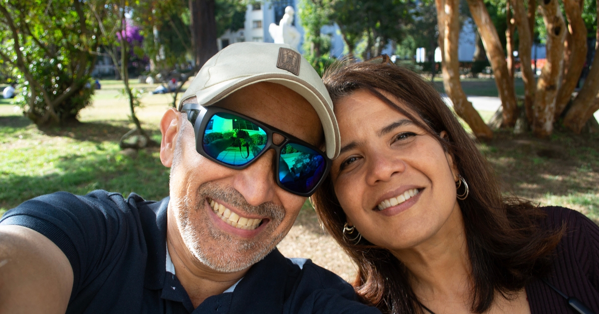 50 and Fabulous_ Rediscovering Romance in Midlife - Mature Singles Finding Love Smiling middle-aged couple enjoying a sunny day at the park, symbolizing joyful midlife romance and dating after 50.