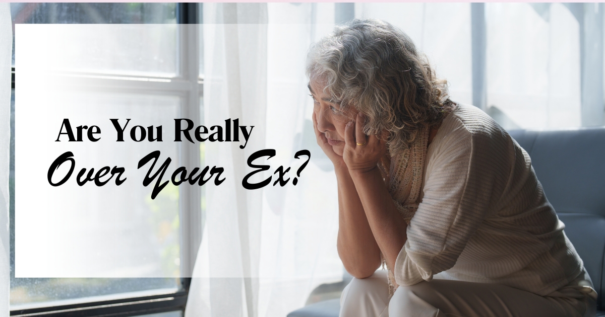 Older woman sitting thoughtfully by a window, looking pensive with hand on chin — concept of emotional healing after breakup, readiness to date again, and self-reflection for mature singles.