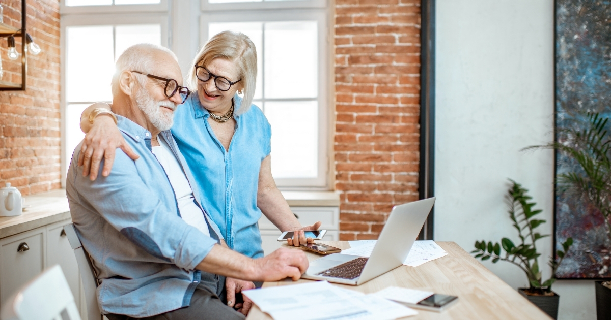 Financial Planning_ Building Security and Freedom for the Future - Mature Singles Finding Love Senior reviewing financial documents on a laptop with charts and graphs, symbolizing retirement planning and financial security for the future.