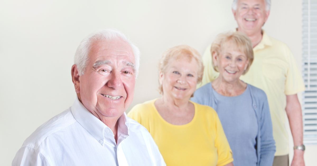 How to Balance Independence and Intimacy in Mature Relationships - Mature Singles Finding Love Group of smiling older adults standing together indoors, representing community, connection, and mature relationships.