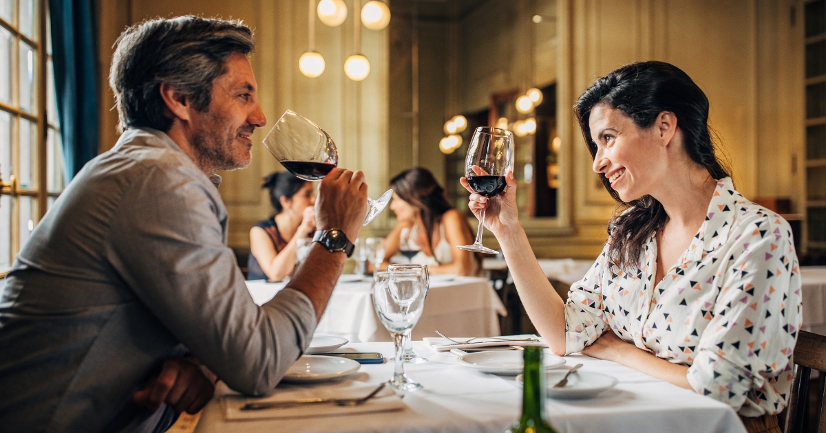 Happy couple enjoying a romantic dinner with red wine at an upscale Philadelphia restaurant – perfect date night idea for mature singles