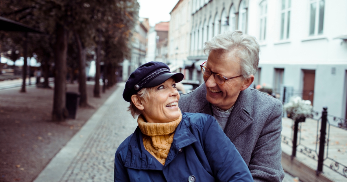 Happy senior couple embracing outdoors on a city street, symbolizing joy and connection in mature relationships with clear expectations.