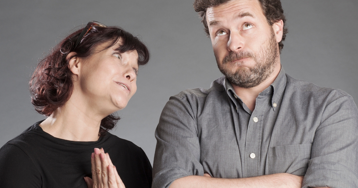 Woman pleading with a man who looks skeptical and has arms crossed, representing uncertainty or hesitation in a romantic conversation.