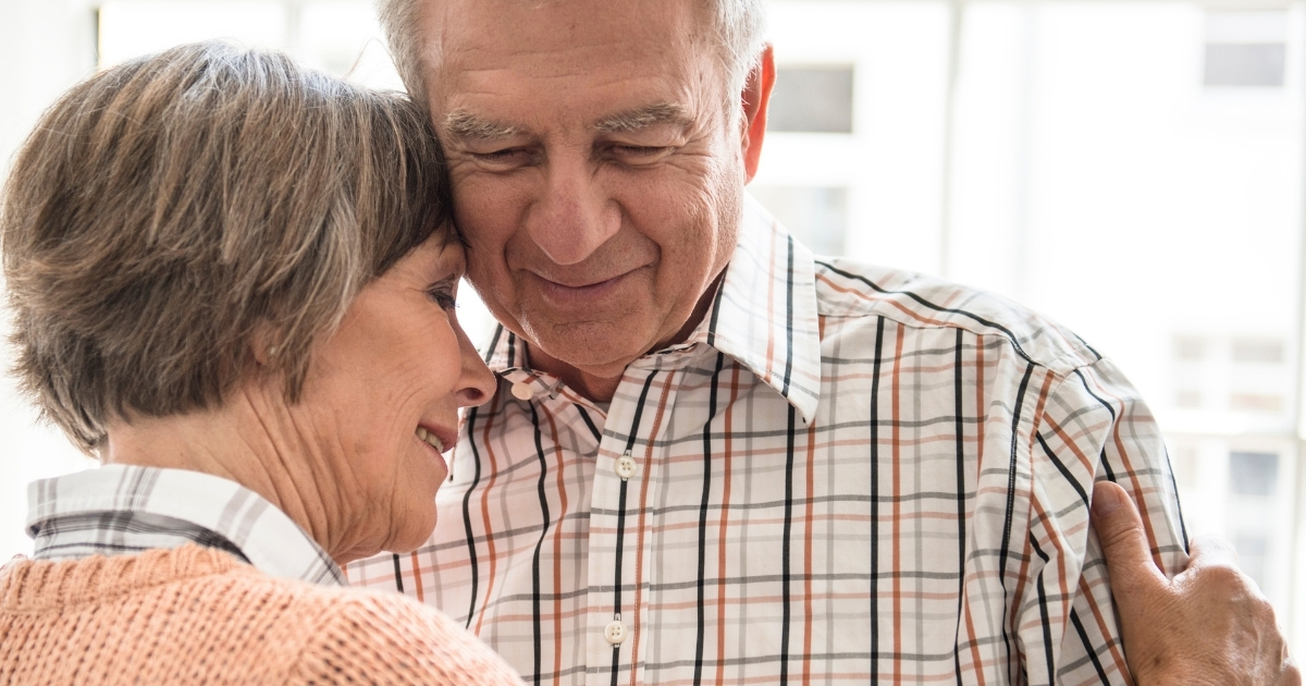 Senior couple embracing tenderly, smiling and enjoying a close, loving moment.