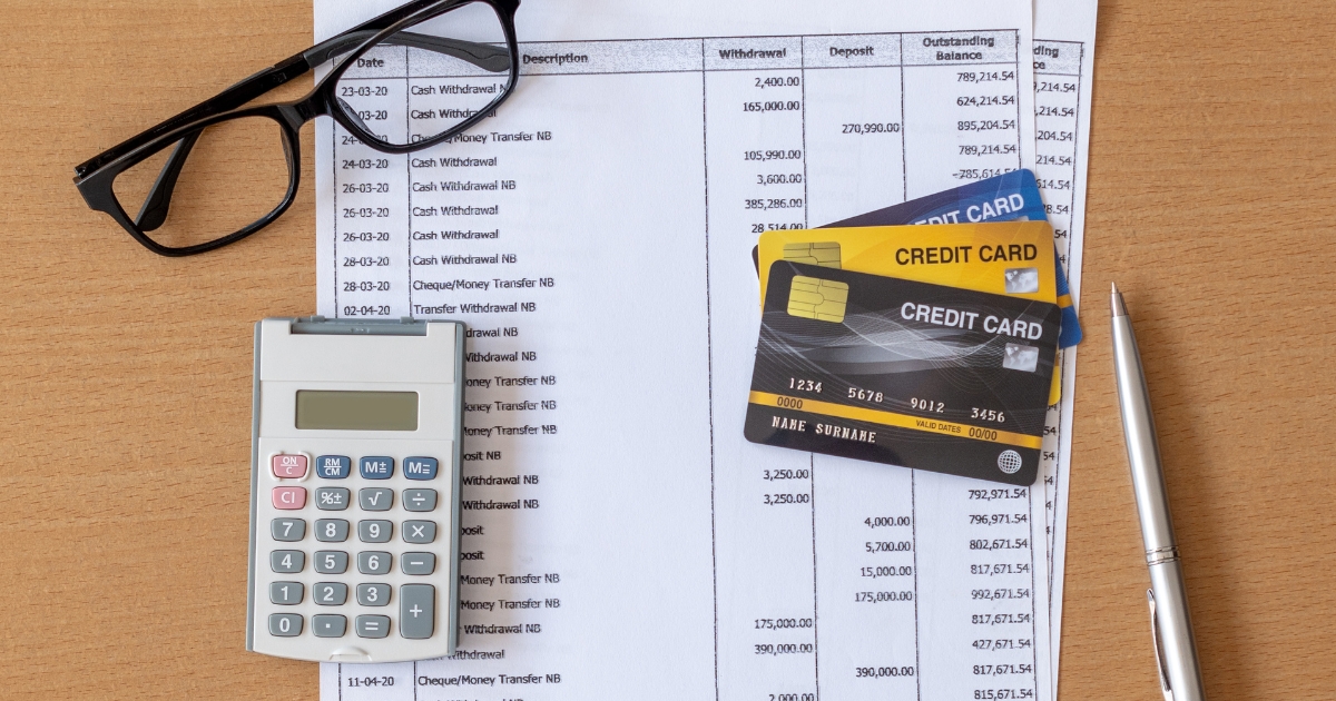 Financial documents, credit cards, calculator, and glasses on a desk, representing budget planning, debt management, and financial organization after divorce.