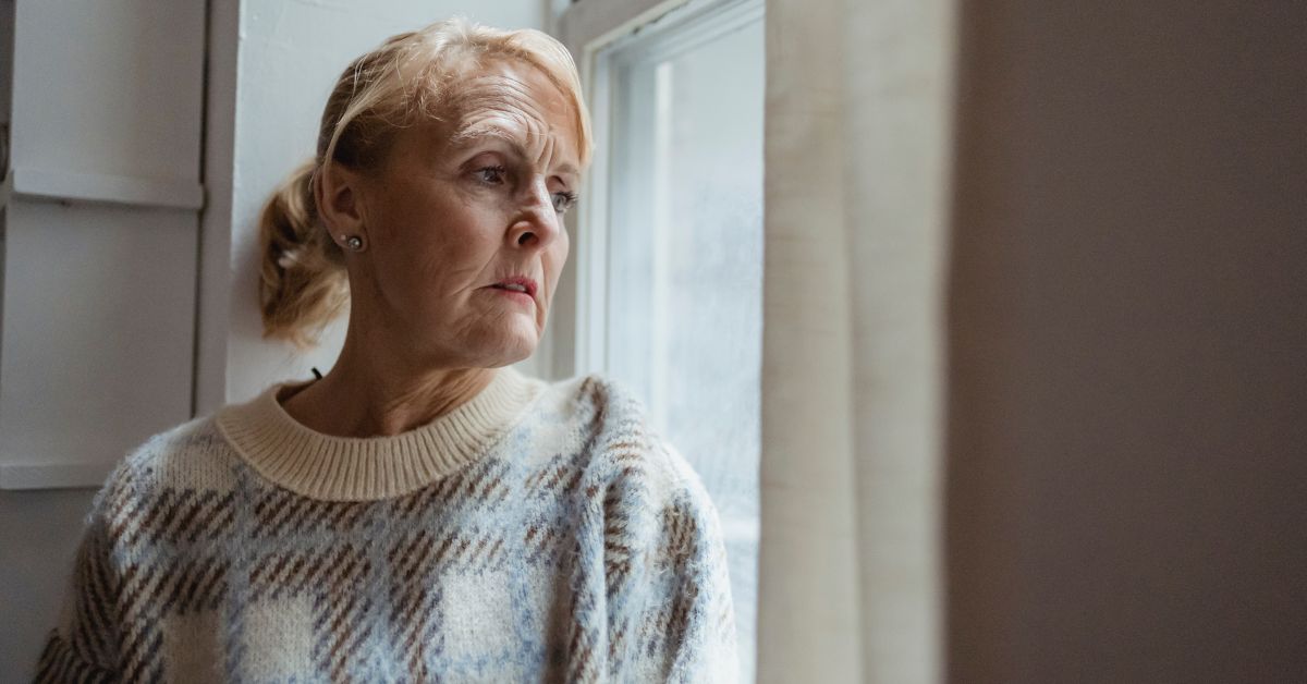 Older woman looking out the window, reflecting during a rough patch in a relationship