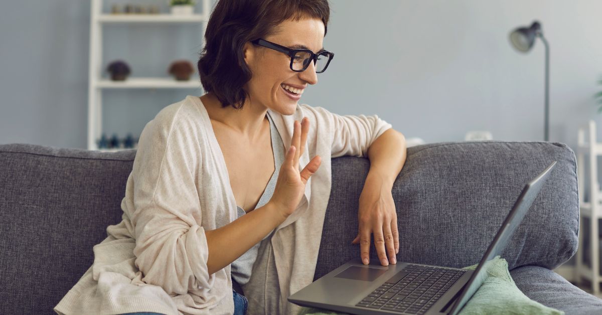 Smiling woman on a virtual date via video chat on laptop