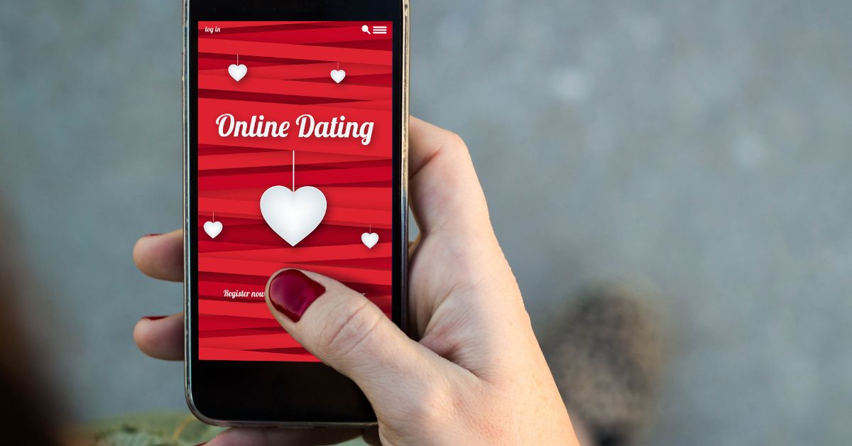 Hand using online dating app on mobile phone with heart icons