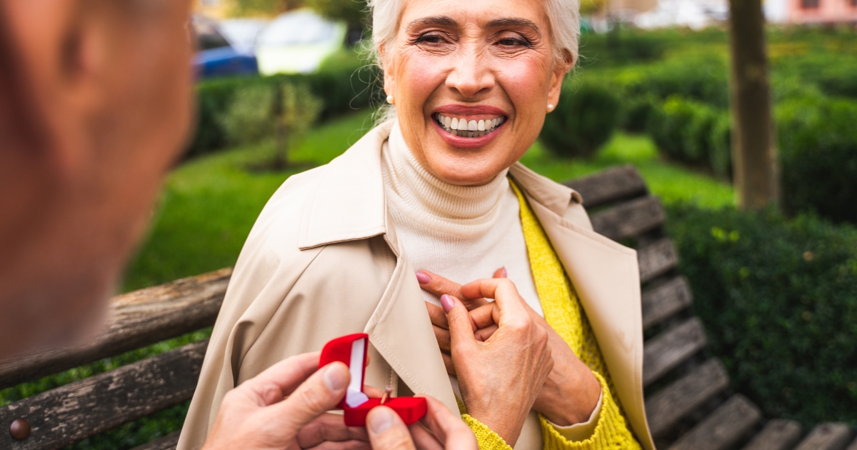 Popping The Question_ Is It The Right Time - Mature Singles Finding Love Senior couple engagement proposal in a park – elderly man proposing to smiling woman with a ring box. Romantic outdoor marriage proposal for older couples.