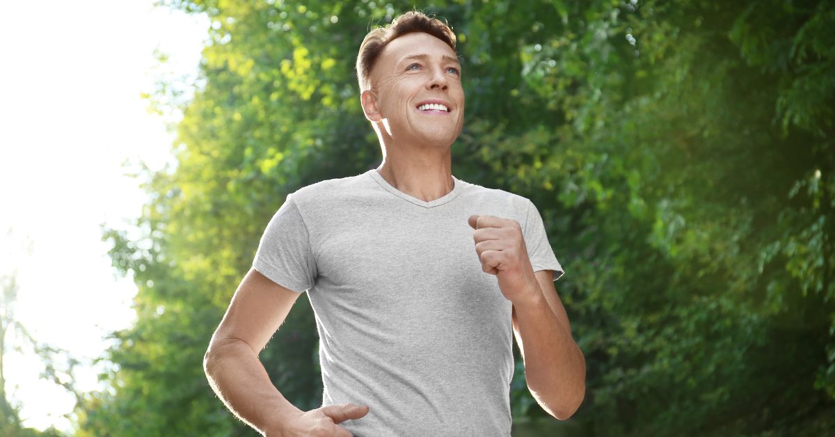 Reclaiming Yourself After Divorce_ Tips for Self-Discovery Later in Life2 - Mature Singles Finding Love Happy middle-aged man jogging in a forest trail, embracing healthy lifestyle