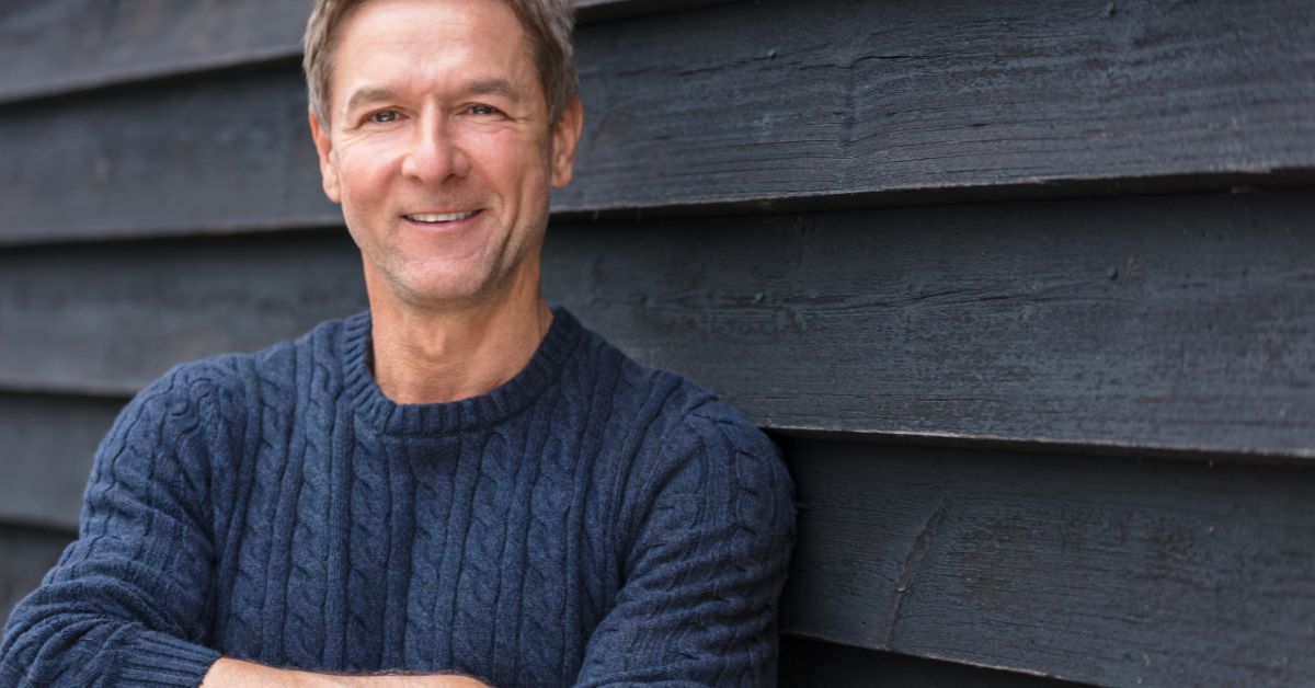 Confident middle-aged man smiling in casual sweater, symbolizing self-assurance after divorce