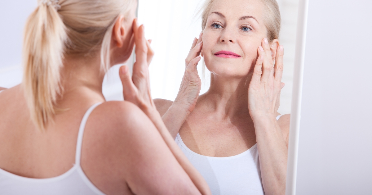 Self-Love and Its Impact on Dating in Your 50s - Mature Singles Finding Love Confident older woman practicing self-love by looking at herself in the mirror, embracing self-acceptance and beauty in her 50s.