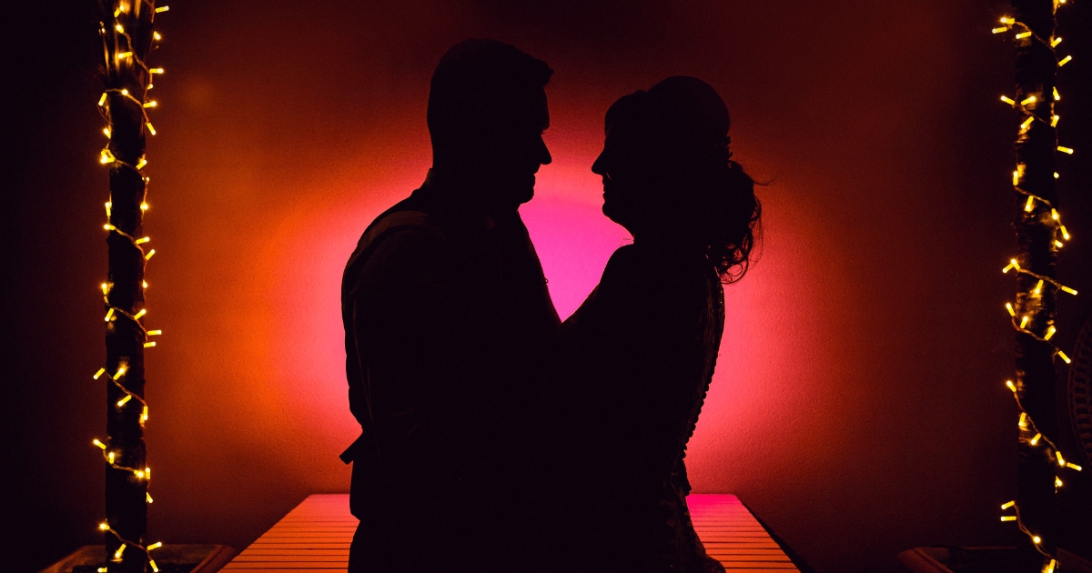 Senior Sex Tips For Men Over 70 - Mature Singles Finding Love Romantic silhouette of a couple embracing under warm lights.