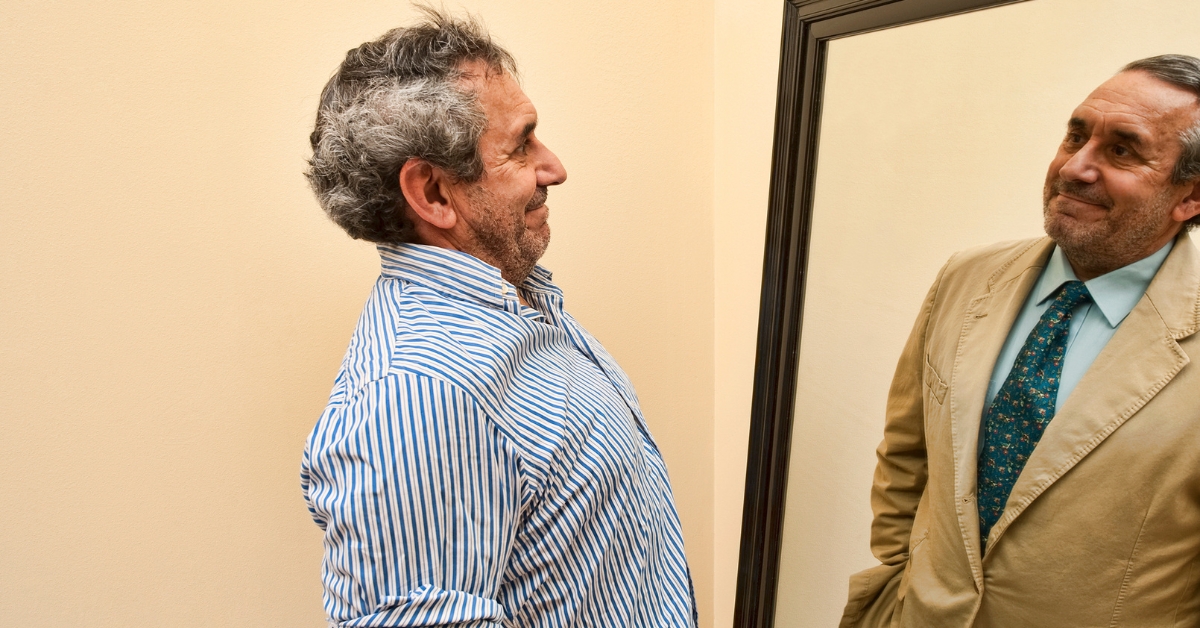 Sex Self-Discovery_ Understanding Your Desires in Your 50s - Mature Singles Finding Love Man in his 50s sees a confident version of himself in the mirror, symbolizing self-discovery and personal growth.