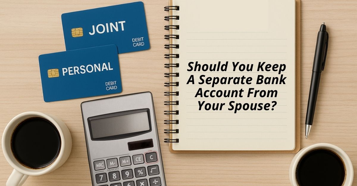 Flat lay of a notebook with the question "Should You Keep a Separate Bank Account From Your Spouse?" alongside debit cards labeled "Joint" and "Personal," a calculator, a pen, and two cups of coffee on a wooden desk.