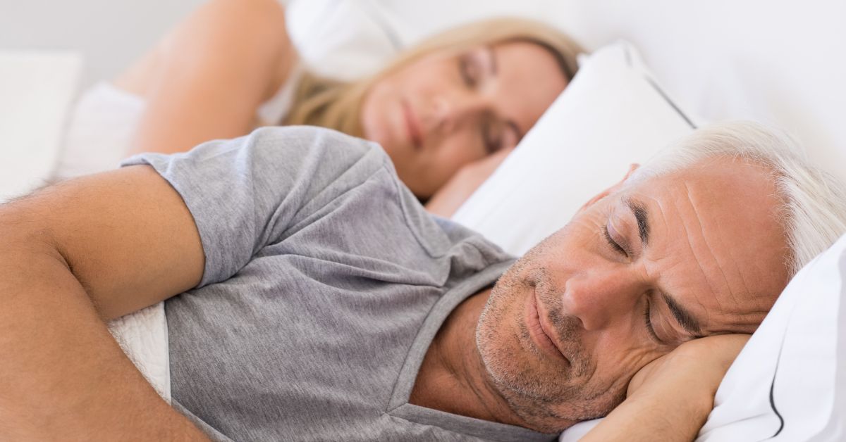 Should You Stay In A Sexless Relationship - Mature Singles Finding Love Older couple sleeping in bed with their backs turned, symbolizing emotional distance or a sexless relationship in a long-term partnership.