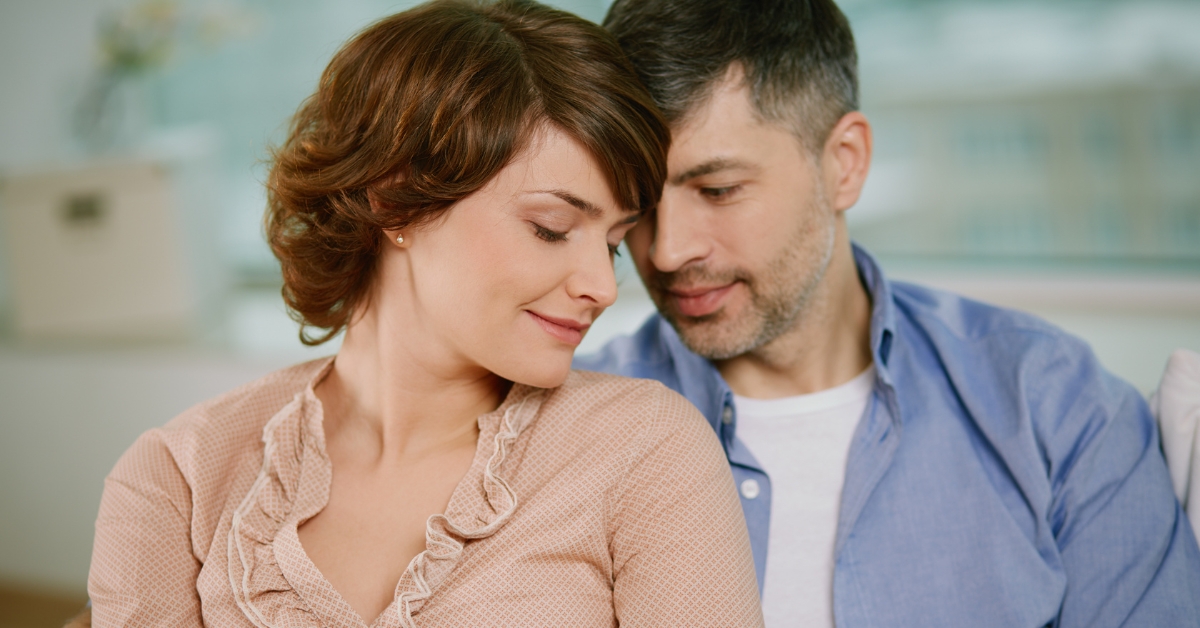The Art of Flirting_ Techniques and Boundaries - Mature Singles Finding Love A couple engaging in subtle flirting through body language, with the man leaning in and the woman smiling gently, showcasing romantic connection and attraction.
