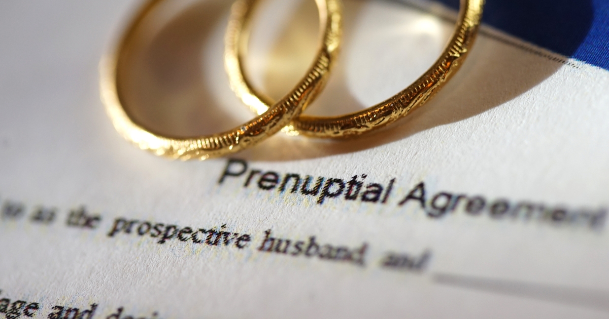 Wedding rings resting on prenuptial agreement paperwork for seniors