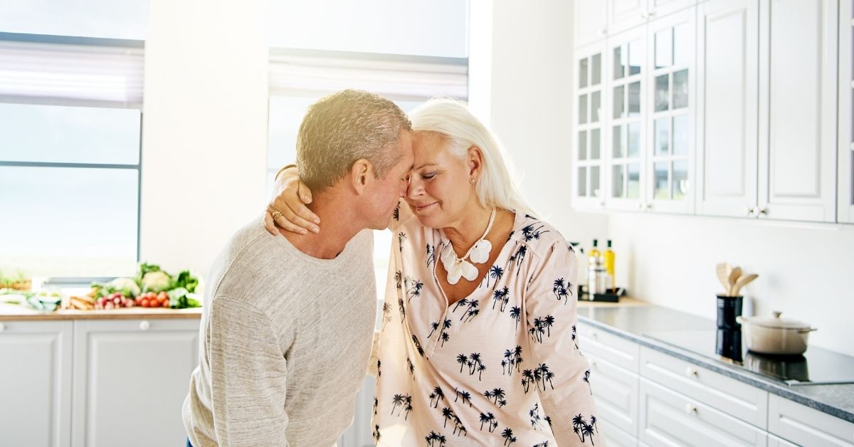Mature couple sharing a tender moment at home, representing love and emotional closeness in later life