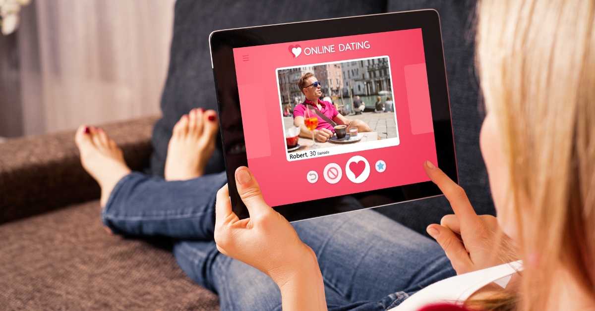 Tips for a Healthy Relationship with Your Dating App - Mature Singles Finding Love Woman using an online dating app on a tablet while relaxing on a couch.