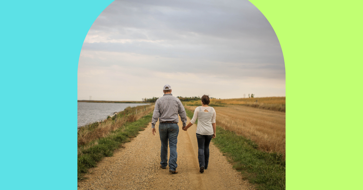 Understanding and Overcoming Ageism in the Dating World - Mature Singles Finding Love An older couple walking hand in hand on a scenic dirt path by the water, symbolizing connection, companionship, and overcoming age-related challenges.