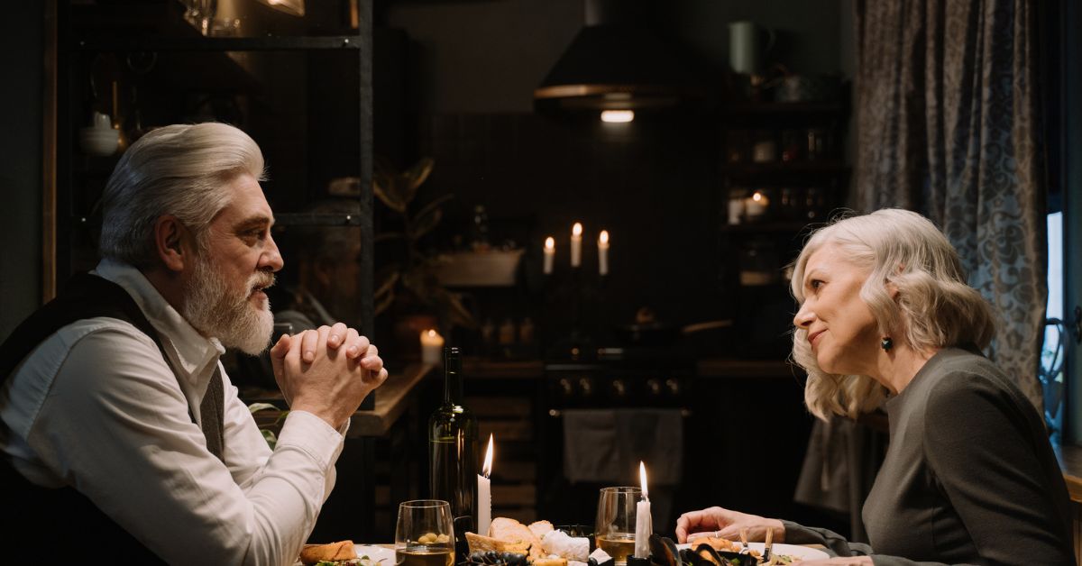 Mature couple enjoying a candlelit dinner at home, representing deep connection, emotional intimacy, and meaningful relationships in later life.