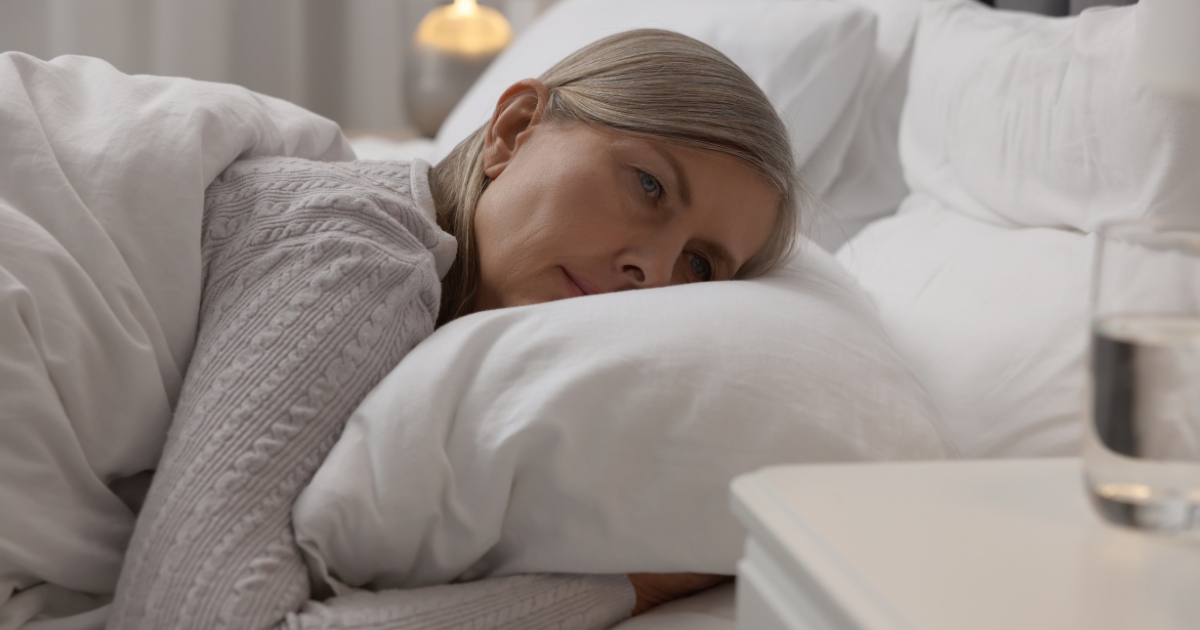 Menopause and sleep disturbances—woman looking restless in bed.