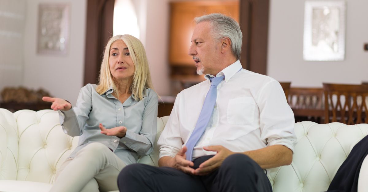 Older couple having a serious conversation on the couch, discussing relationship issues