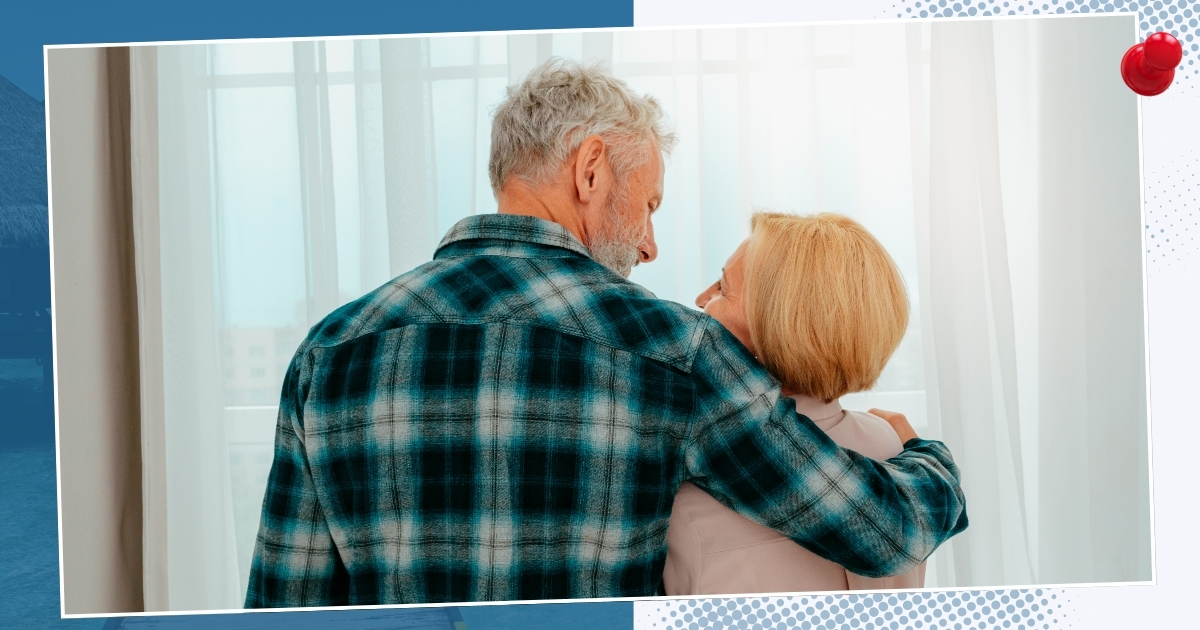 "Happy mature couple embracing and enjoying casual companionship near a window – dating over 50"